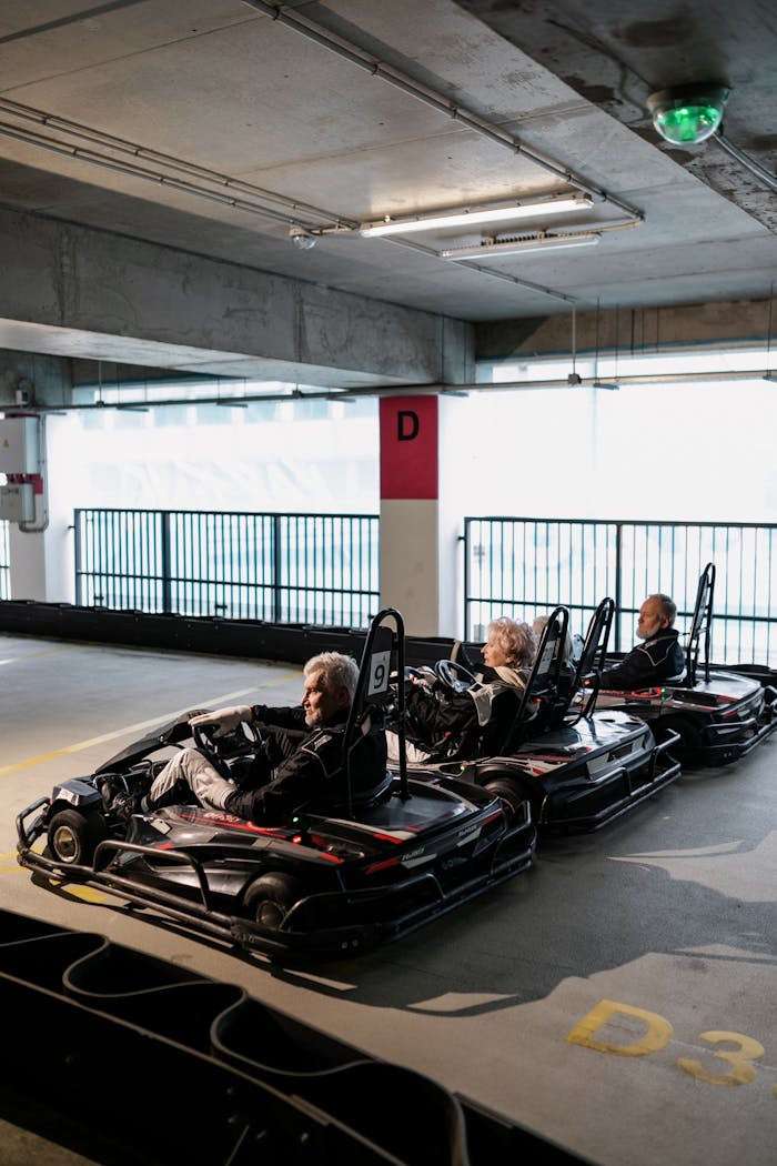 Senior adults enjoying a thrilling go-kart race indoors, depicting fun and friendship.