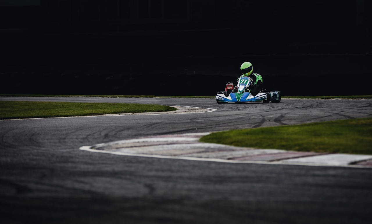 Dynamic photo of a go-kart racer speeding through a tracks curve, showcasing the thrill of motorsport.